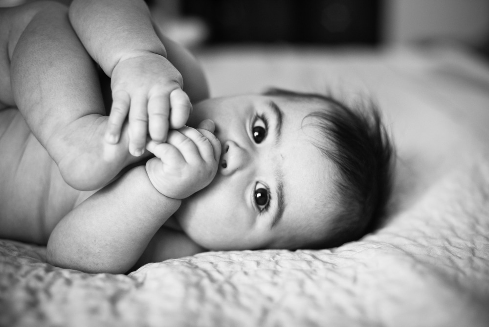 baby with feet in mouth