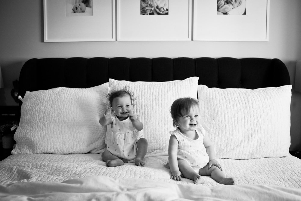 twin baby girls playing on bed