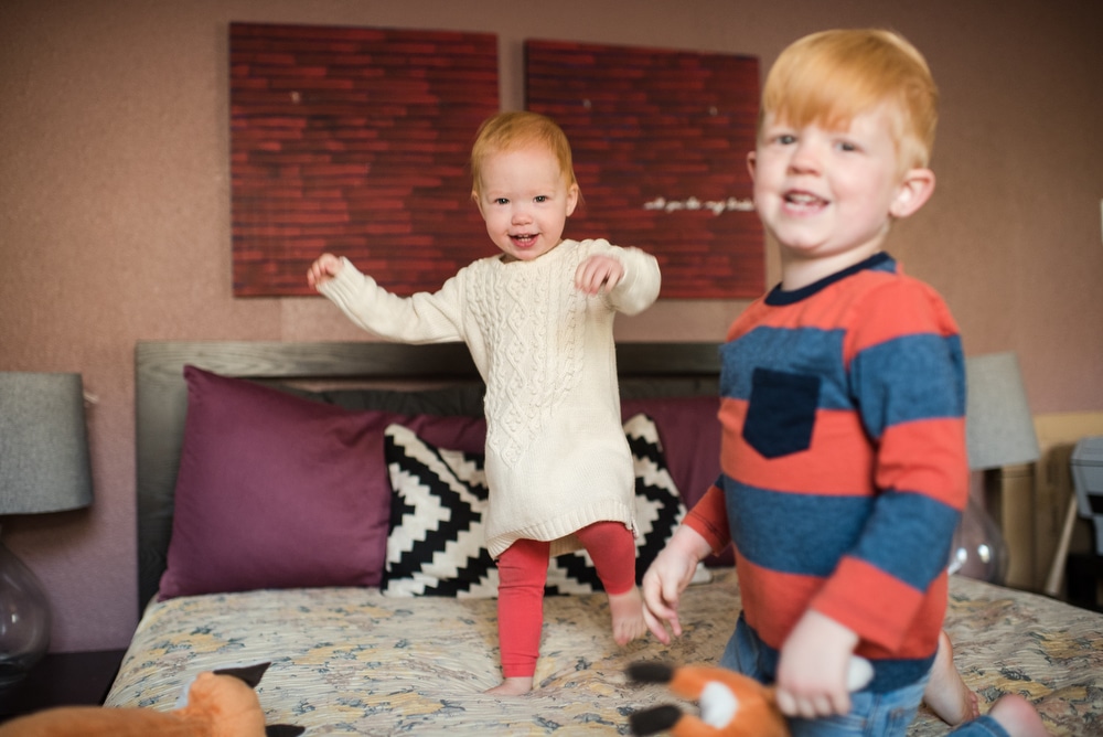 children bouncing on bed