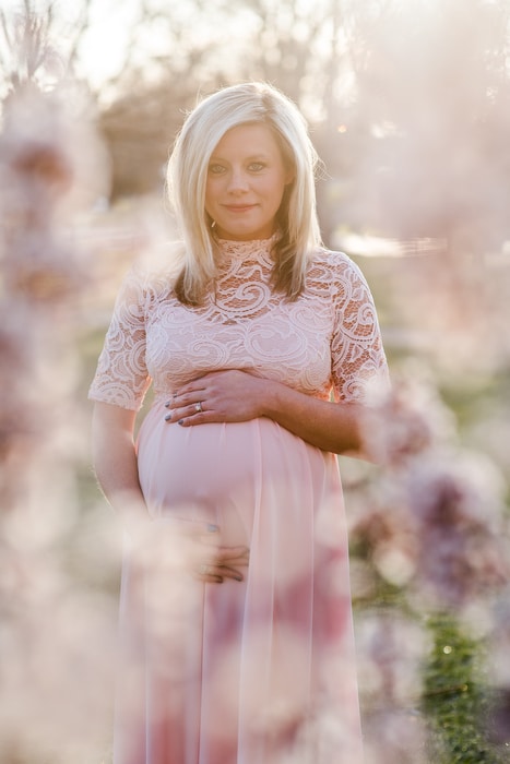 denver maternity portrait with cherry blossoms blooming at City Park